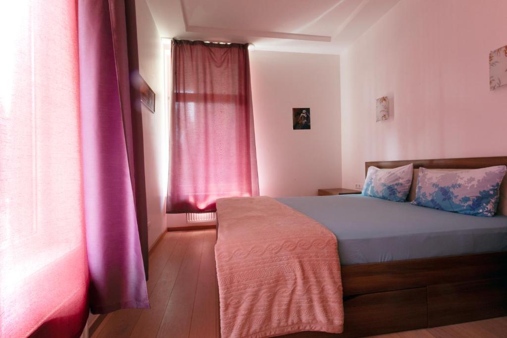 a bedroom with a bed with purple curtains and a window at Cozy apartments in Bulduri in Jūrmala