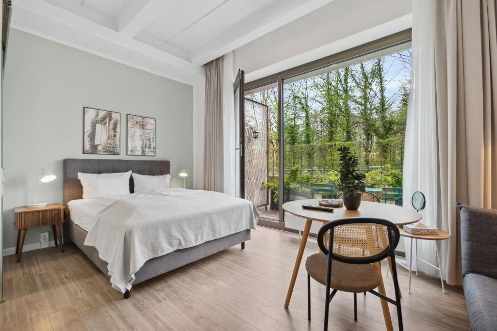 1 dormitorio con cama, mesa y ventana en limehome Munich Fritz-Erler Str, en Múnich