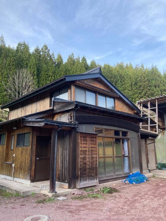 una casa en las montañas con árboles en el fondo en 田舎の別荘 かすみ草 en Shōgahora