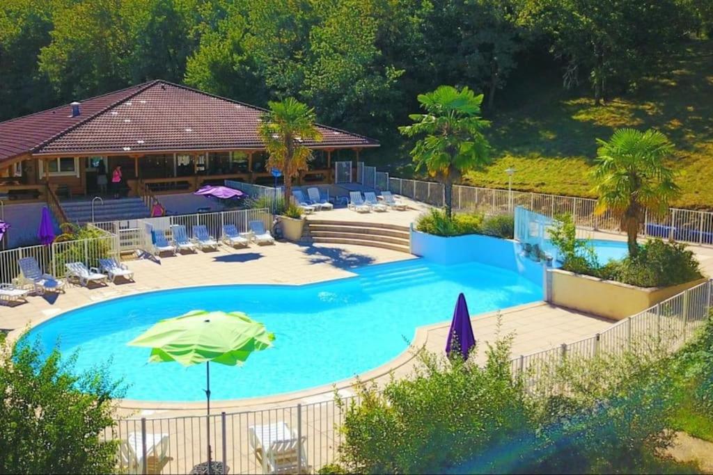 uma vista superior de uma piscina com um guarda-sol e cadeiras em Sfeervolle en ruime chalet Il Mondo em Mauroux