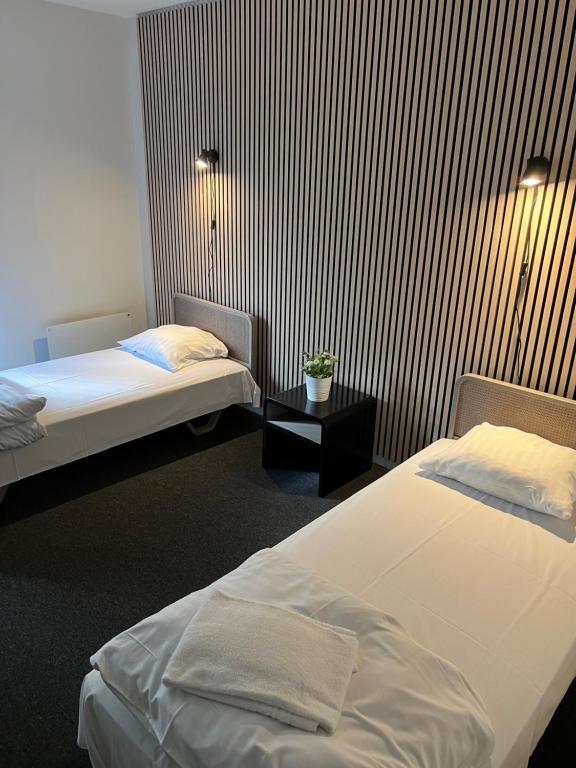 a hotel room with two beds and a table at Skuldelev kro in Skibby