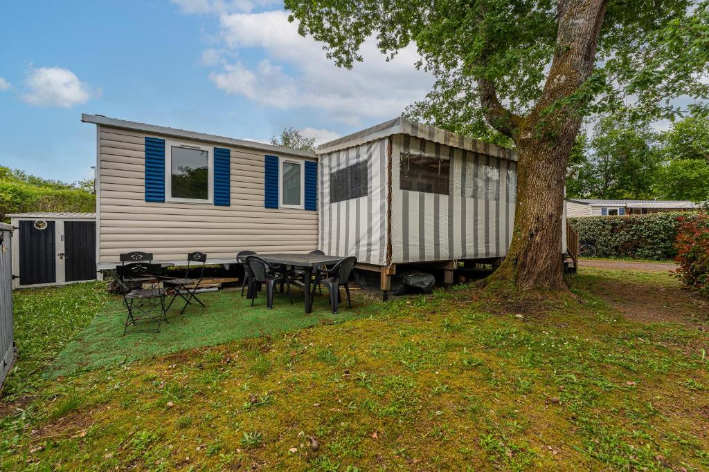 une petite maison avec une table et un arbre dans l'établissement Mobilhome a La reserve, à Gastes