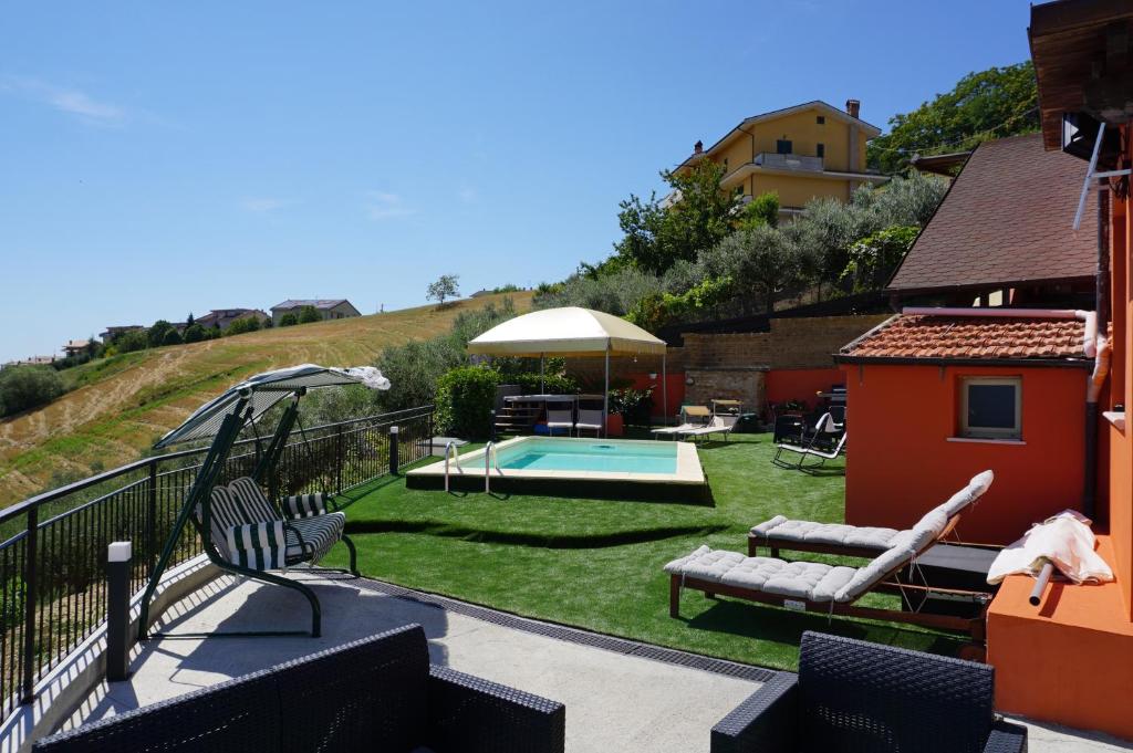 un patio trasero con piscina y una casa en La Terrazza Motta en Atri