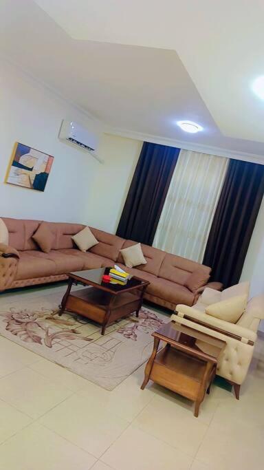 sala de estar con sofá y mesa en شقة فاخرة واسعة في شارع المدينة المنورة, en Umm Uthainah