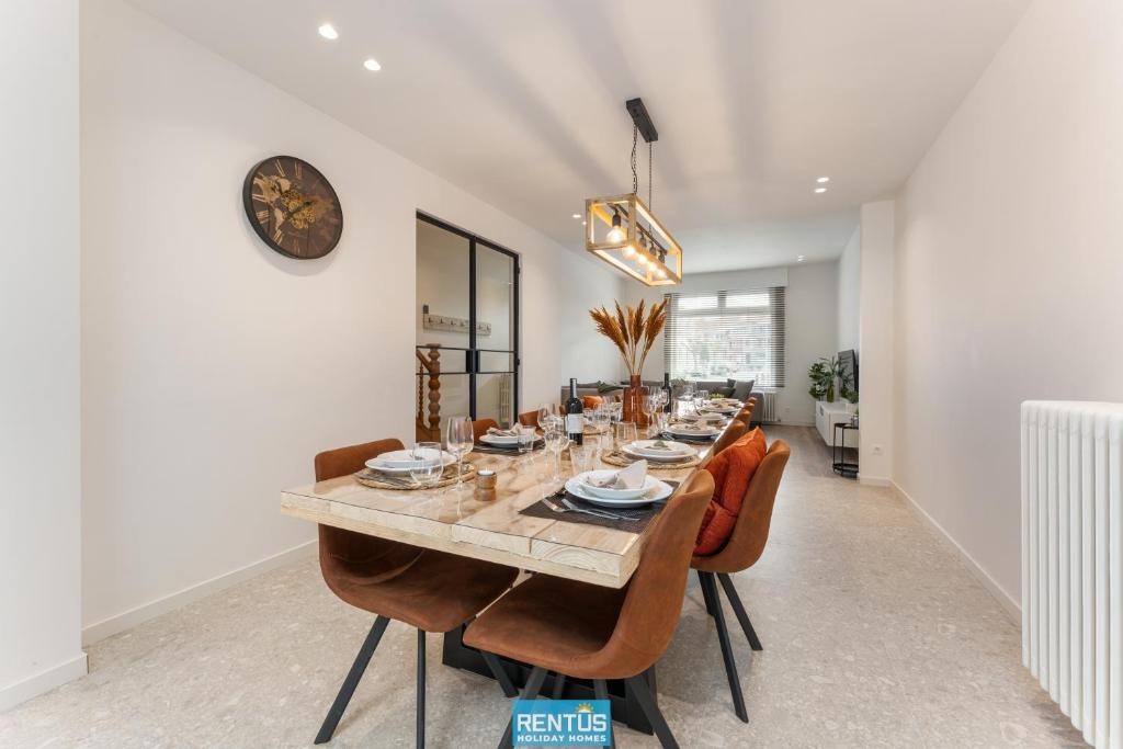 een eetkamer met een lange tafel en stoelen bij Casa Diva – renovated house for 12 in Blankenberge in Blankenberge