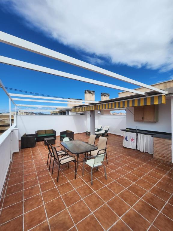 d'une terrasse sur le toit avec une table et des chaises. dans l'établissement Atico Canet, à Canet d'En Berenguer