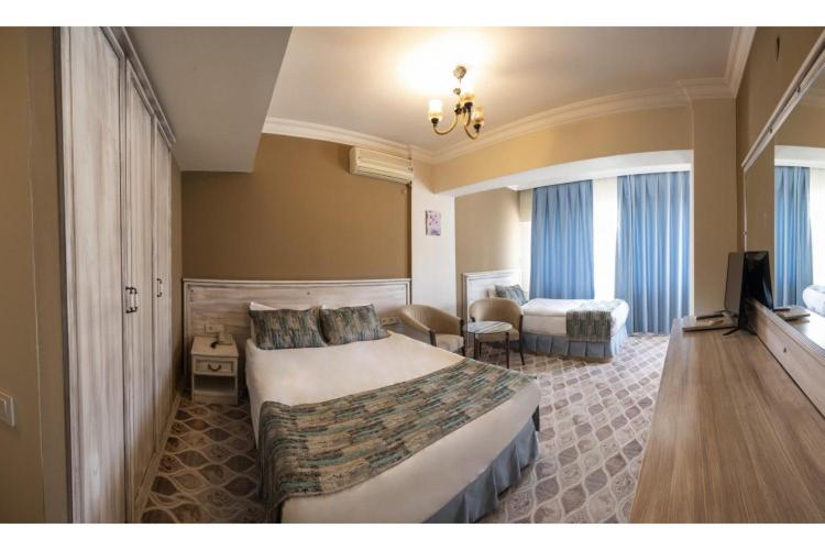 ein Hotelzimmer mit einem großen Bett und einem Sofa in der Unterkunft AĞAOĞLU MY TERMAL in Sadıkbey