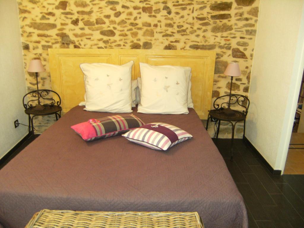 a bedroom with a bed with two pillows on it at Domaine du Fief aux Dames in Monnières