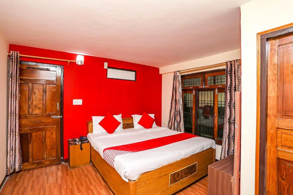 a bedroom with red walls and a bed with red pillows at OYO Flagship View Point Resort in Nainital