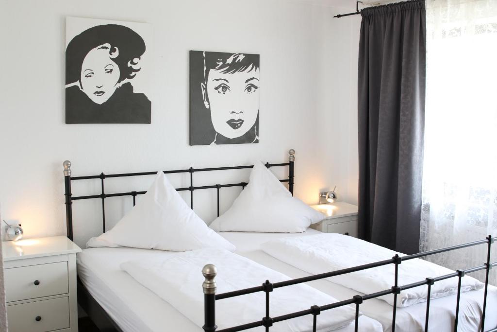 a bedroom with two beds with black and white posters on the wall at Hotel Alka in Bietigheim-Bissingen