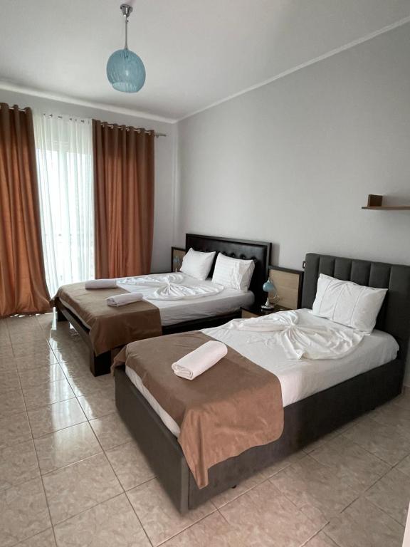 two beds in a hotel room with two bedsitures at Hotel Aleksandrus Jardin in Durrës