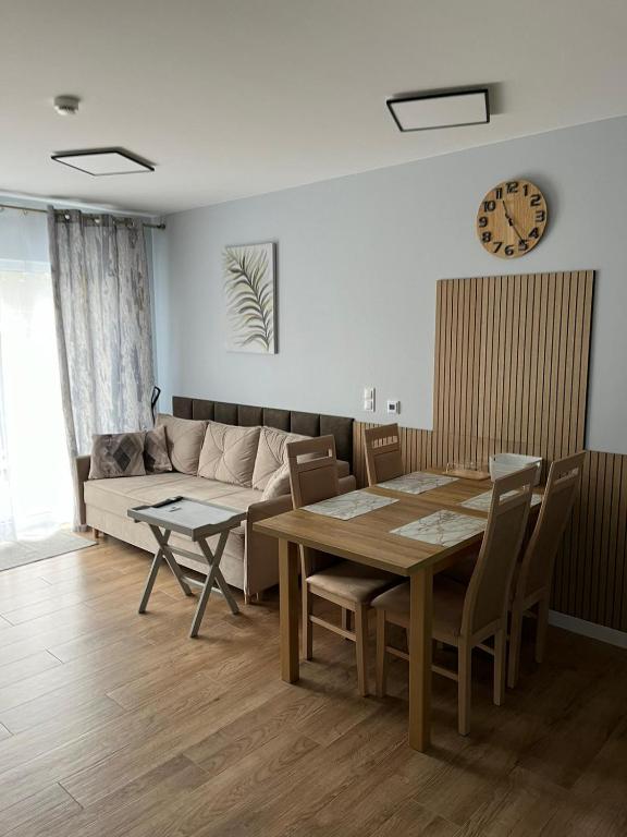 a living room with a table and a couch at Apartament AMBRA II in Jantar