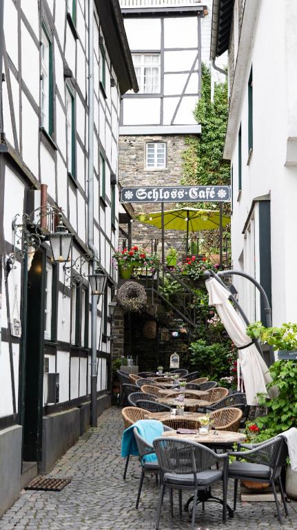 an alley with tables and chairs on a building at Hotel Royal in Monschau