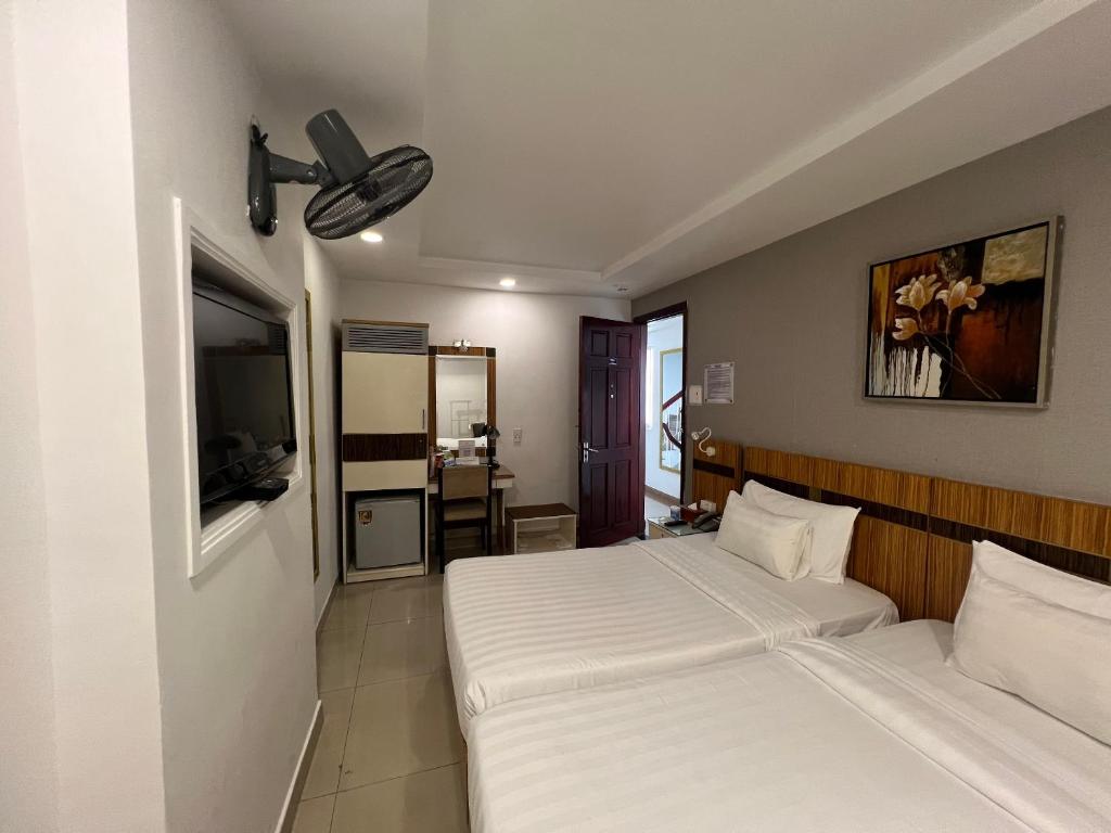 een slaapkamer met 2 bedden en een flatscreen-tv bij A25 Hotel - 13 Bùi Thị Xuân in Ho Chi Minh-stad