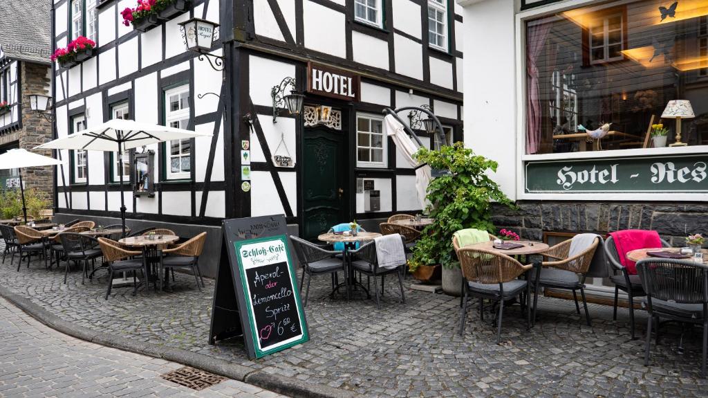 a restaurant with tables and chairs in front of a building at Hotel Royal in Monschau