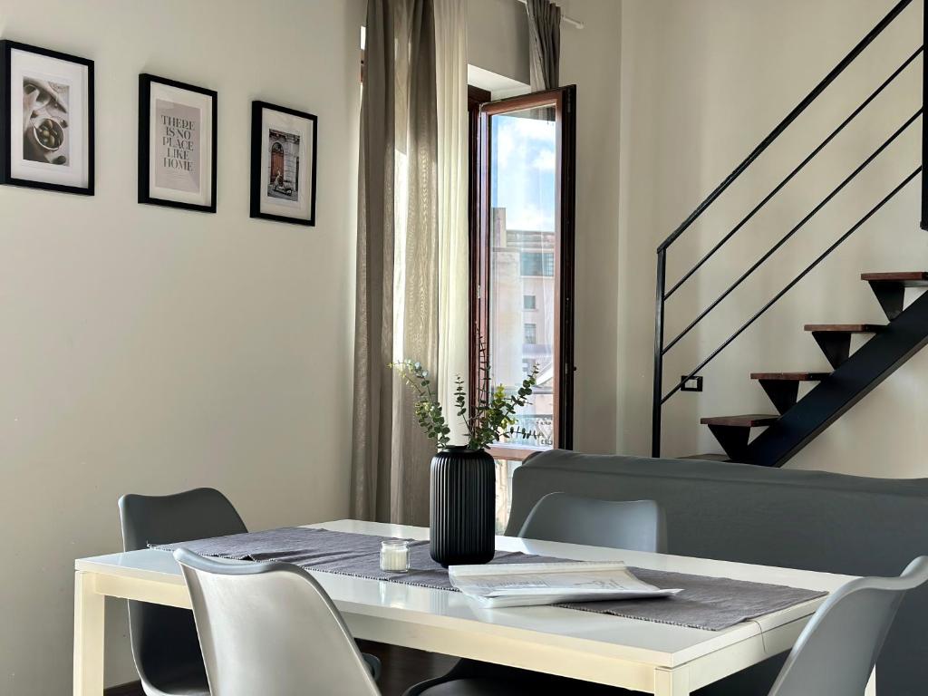 - une table à manger avec des chaises et un vase dans l'établissement Le Quattro Chiavi, à Palerme