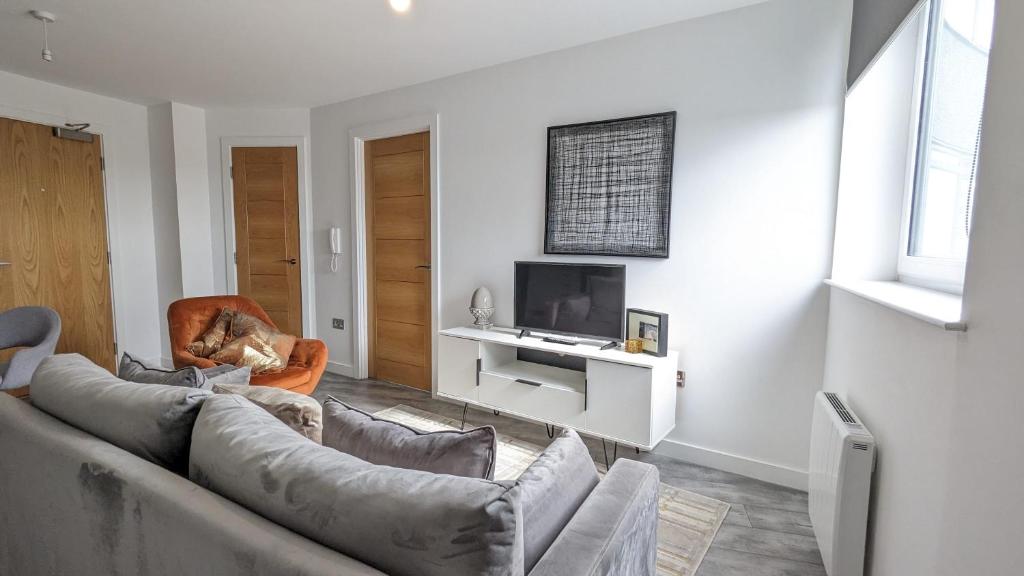 a living room with a couch and a tv at Modern 1 Bed Apt - 15 Mins to Bham Centre in Birmingham