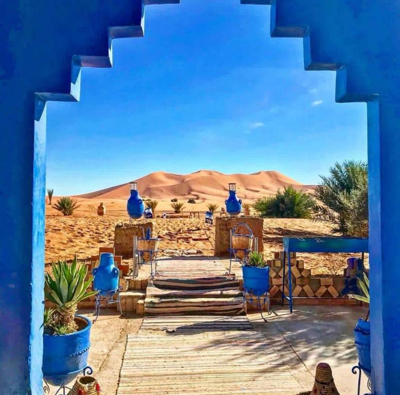 a view from a house in the desert at Hotel Camping Les Roses Des Dunes in Merzouga