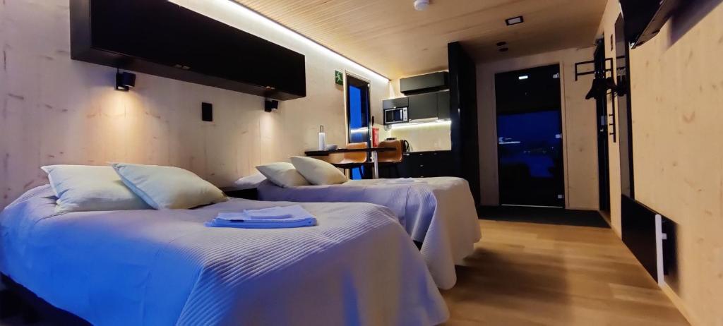 um quarto de hotel com duas camas e uma televisão em Hotel OmaBox - Nivala - Oma huoneisto saunalla em Nivala