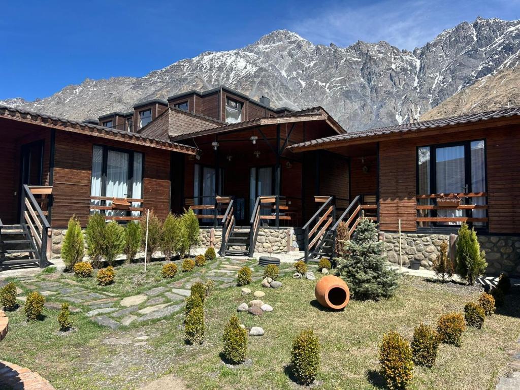 a log cabin with mountains in the background at Panorama Cottages in Stepantsminda
