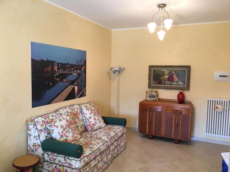ein Wohnzimmer mit einem Sofa und einem Gemälde an der Wand in der Unterkunft Appartamento 500 metri dal mare in Tortoreto Lido