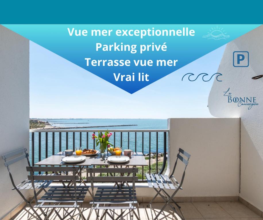 una mesa en un balcón con vistas a la playa en Le Maeva PLage - Vue mer d'exception - Parking privé - La Grande Motte en La Grande-Motte