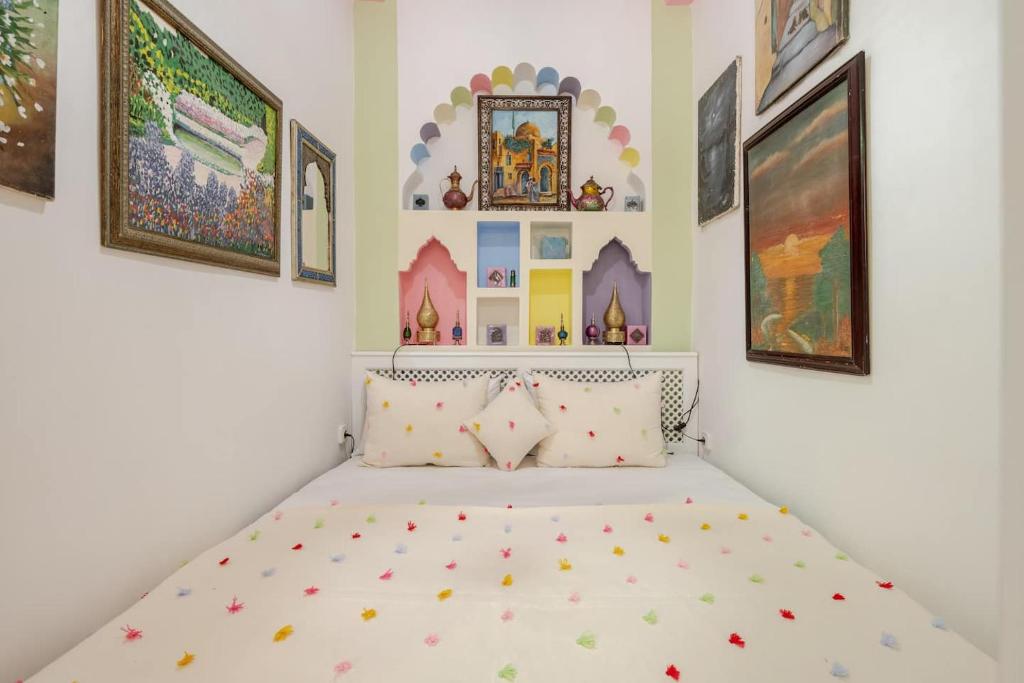 Cama en habitación con pinturas en la pared en Studio Arc en Ciel de la Kasbah, en Tánger