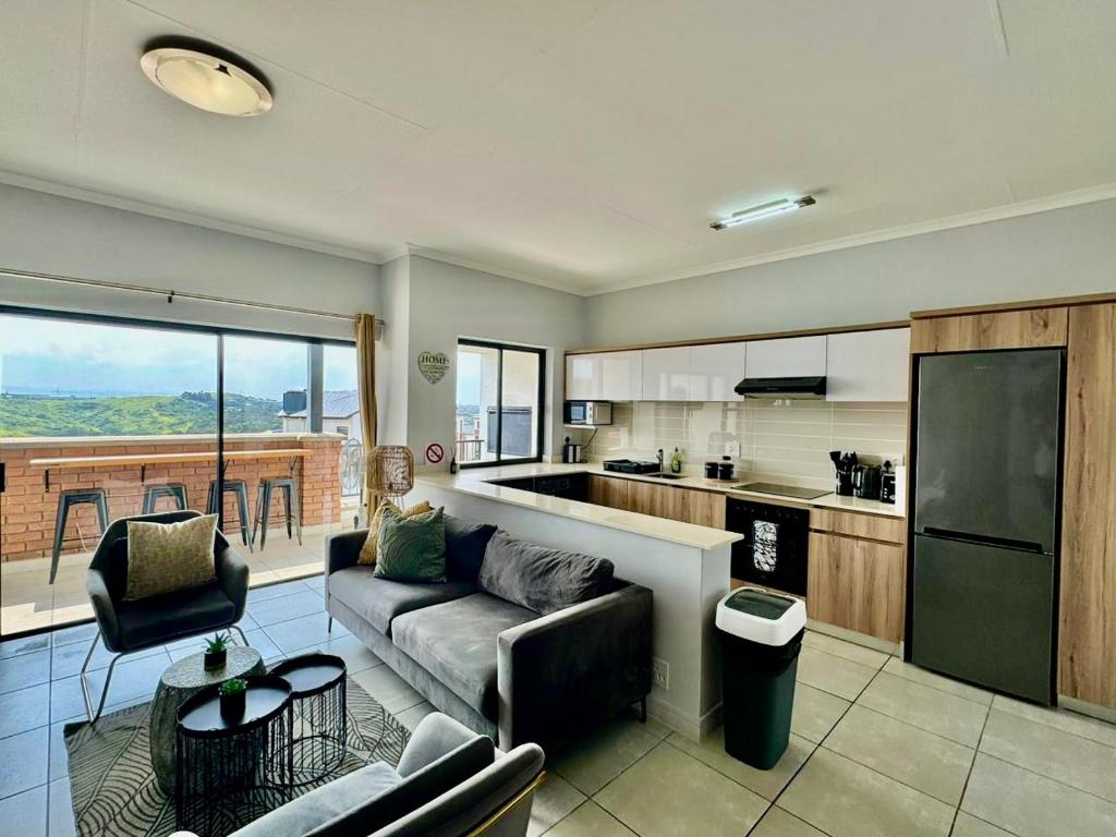 een woonkamer met een bank en een keuken bij Ballito Hills 2 bedroom apartment 1272 in Ballito