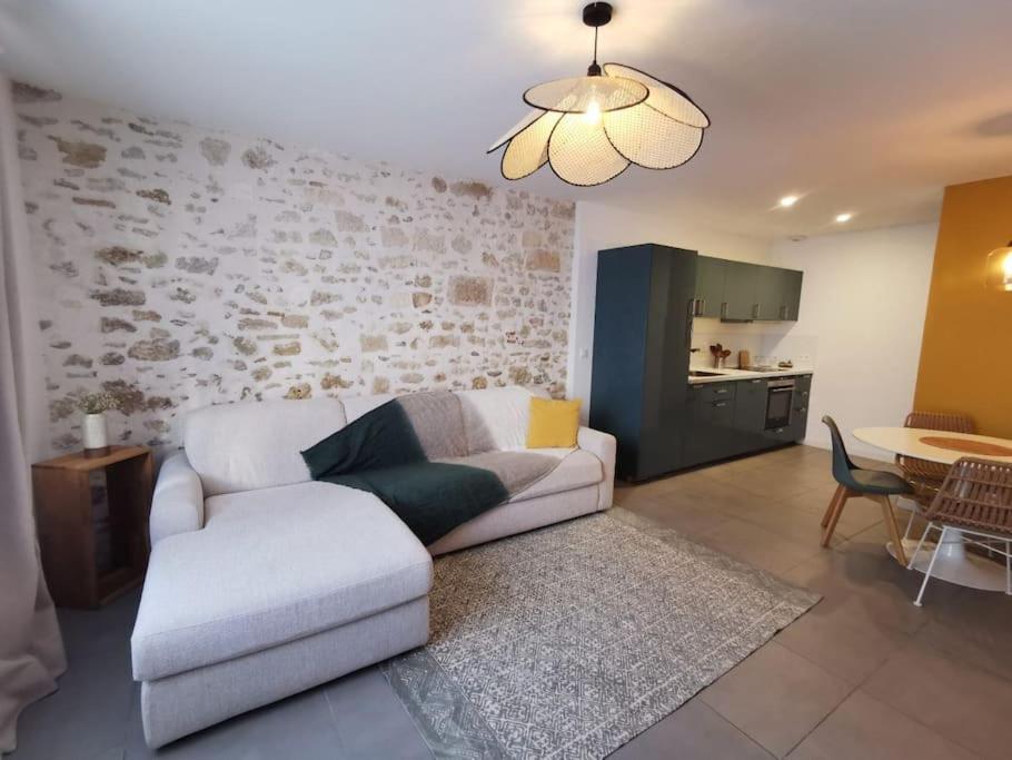 uma sala de estar com um sofá branco e uma cozinha em Appartement cosy aux Beaux-arts em Montpellier
