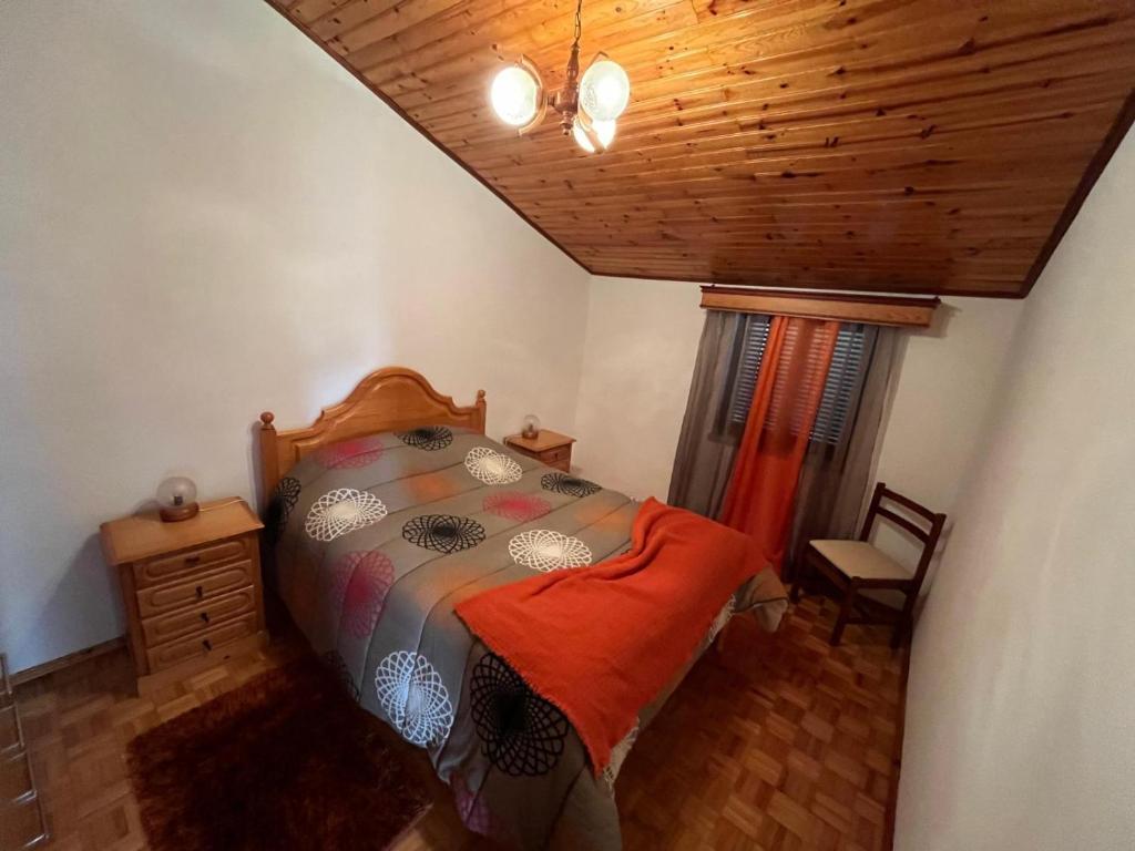 1 dormitorio con cama y techo de madera en Casa do Castelo- Serra da estrela, en Covilhã