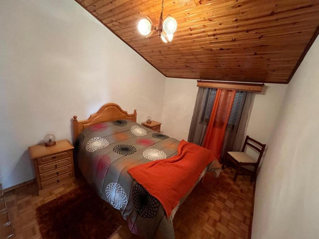 a bedroom with a bed and a wooden ceiling at Casa do Castelo- Serra da estrela in Covilhã