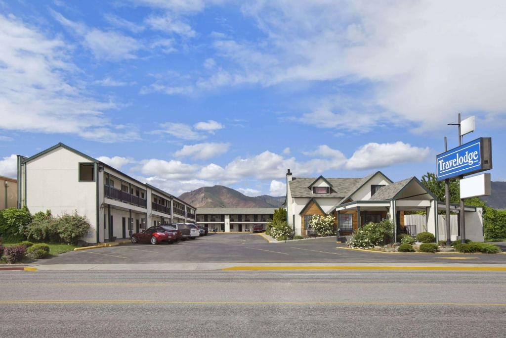 un hotel con coches estacionados en un estacionamiento en Travelodge by Wyndham Wenatchee, en Wenatchee