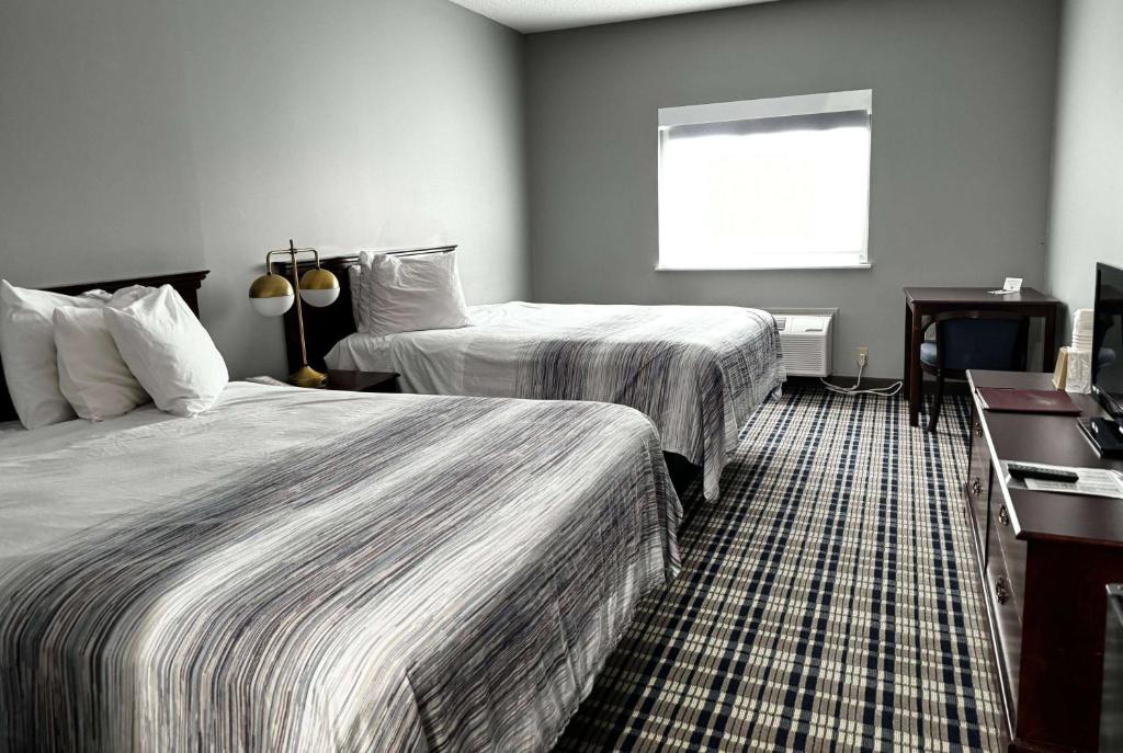 a hotel room with two beds and a window at AmericInn by Wyndham Eagle River Downtown in Eagle River