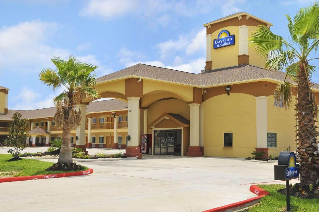 a large yellow building with a parking meter in front at Days Inn by Wyndham Humble/Houston Intercontinental Airport in Humble