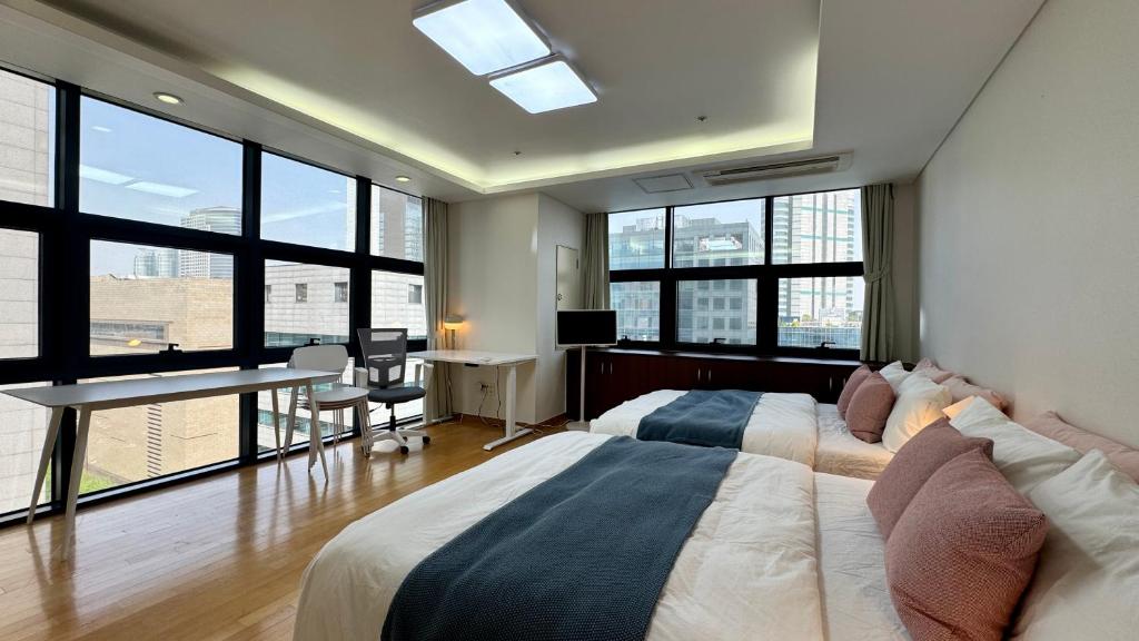 a bedroom with a bed and a desk and windows at COEX VIP 15 New Open [2 Queen beds] in Seoul