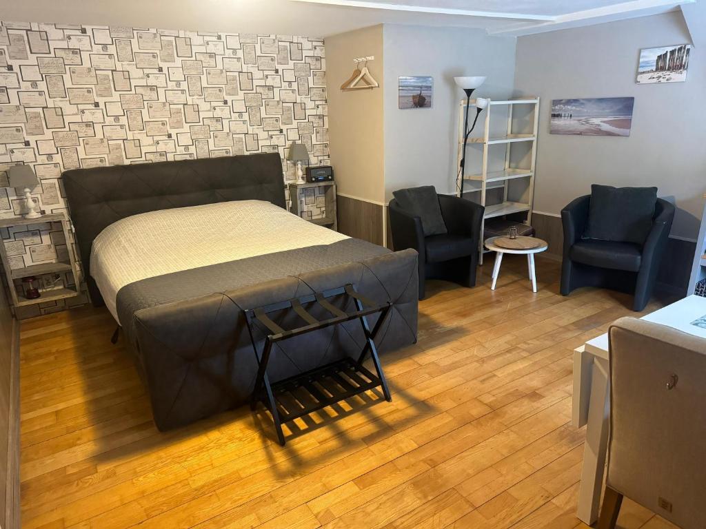 een slaapkamer met een bed en 2 stoelen. bij De Posthoorn in Appelscha