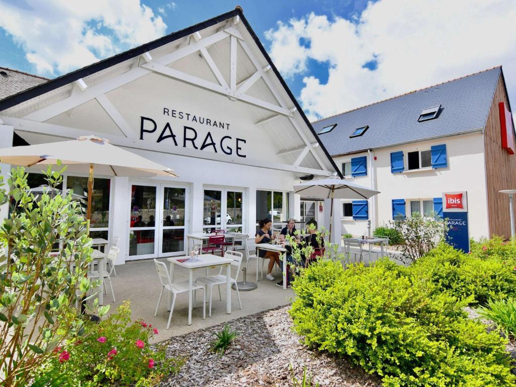 un restaurant avec des tables, des chaises et des parasols dans l'établissement ibis Brest Kergaradec, à Brest