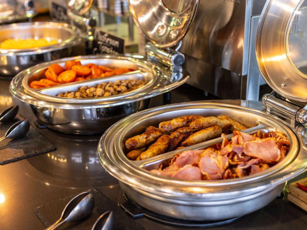 two trays of food on a buffet table at ibis London City - Shoreditch in London