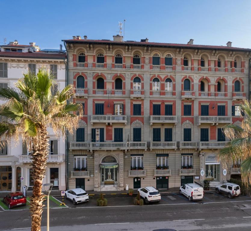 a large building with cars parked in front of it at Hotel Residence Esplanade in Viareggio