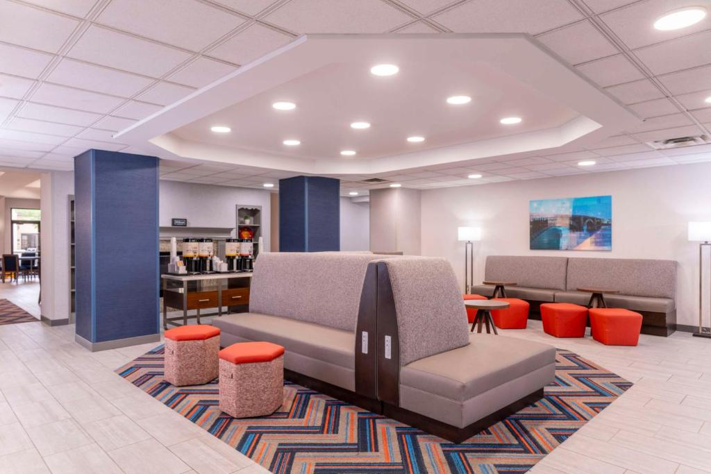 a lobby with a waiting room with a couch andools at Hampton Inn & Suites St. Louis-Chesterfield in Chesterfield