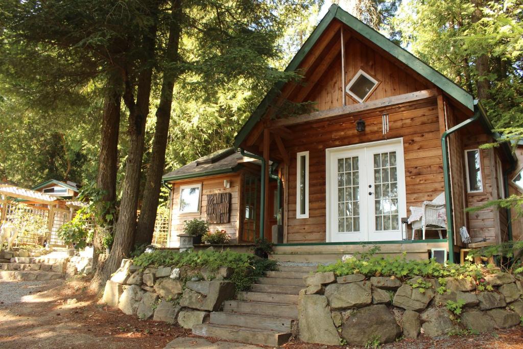 uma pequena casa de madeira com escadas em frente em Thistle Dew Cottage em Ganges