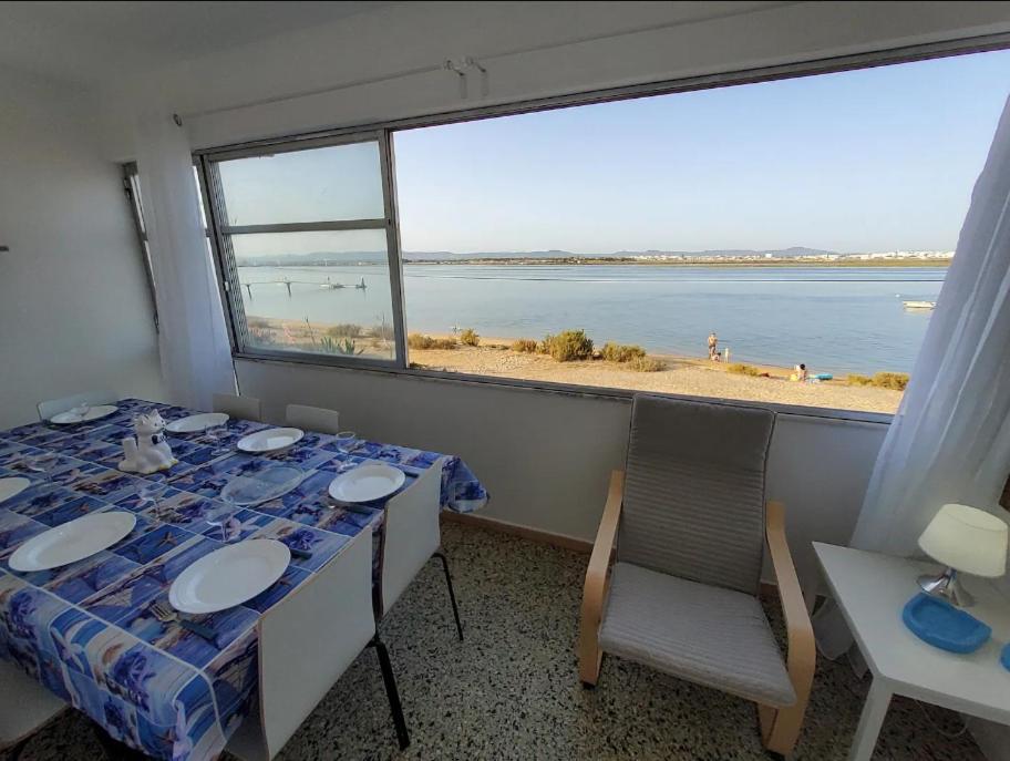 Una habitación con una mesa y vista al mar. en BLife Faya private rooms, en Faro