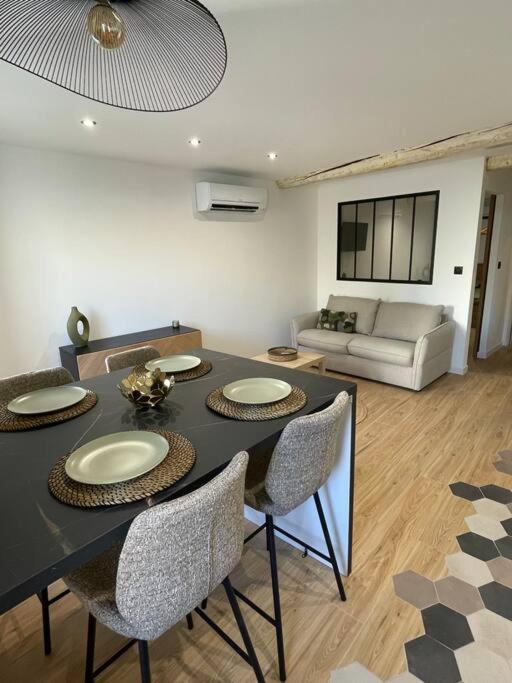 ein Wohnzimmer mit einem Tisch, Stühlen und einem Sofa in der Unterkunft Appartement la ciotat in La Ciotat