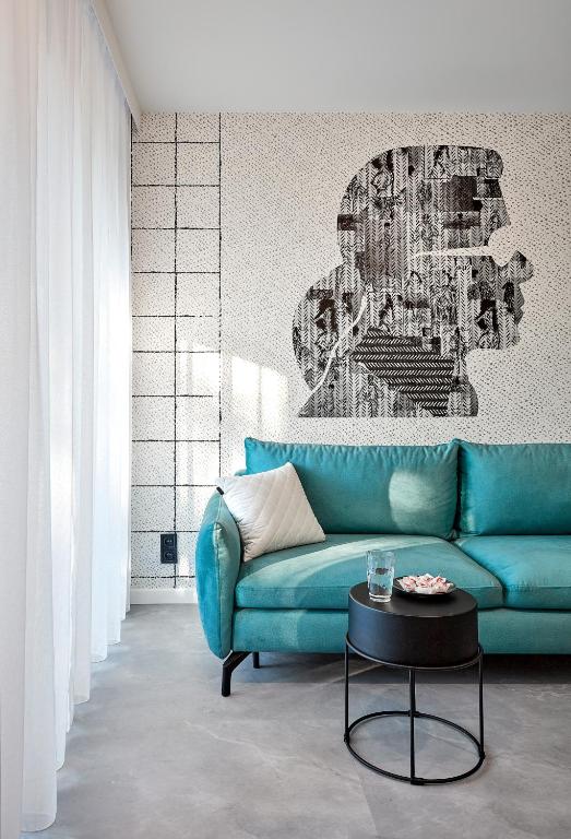 a living room with a blue couch and a table at Premium City Apartments in Bydgoszcz