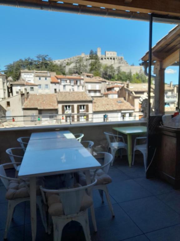 een tafel en stoelen op een balkon met uitzicht bij Les MIRABELLES chambres d'hôtes in Sisteron