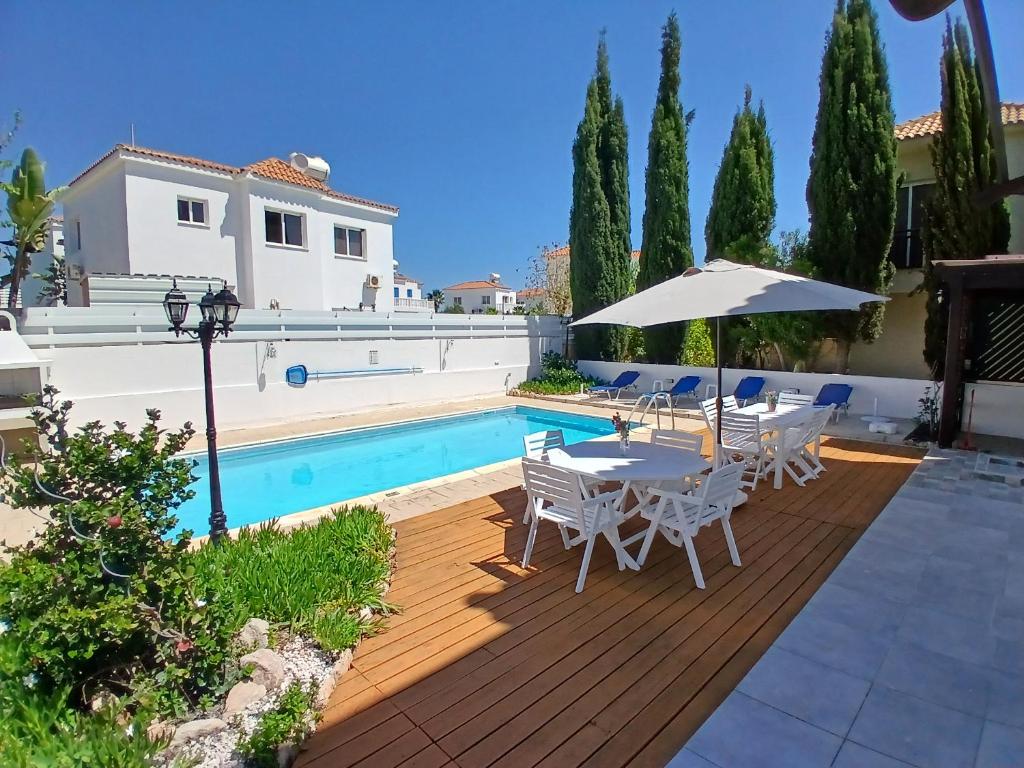 a patio with a table and chairs and a pool at Villa Kiveli in Ayia Napa