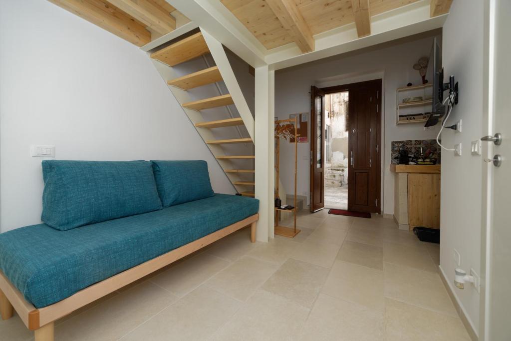 a living room with a blue couch and stairs at Casa Vacanze Ranieri in Grottaglie