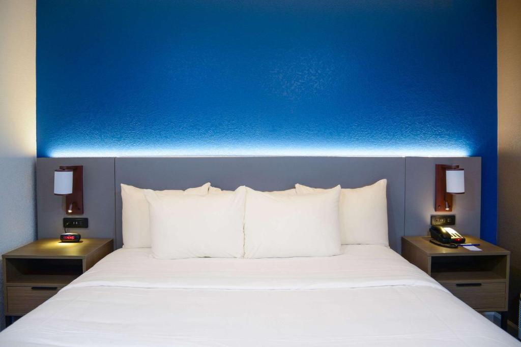 a blue wall above a bed with white pillows at Comfort Inn & Suites Moreno Valley near March Air Reserve Base in Moreno Valley