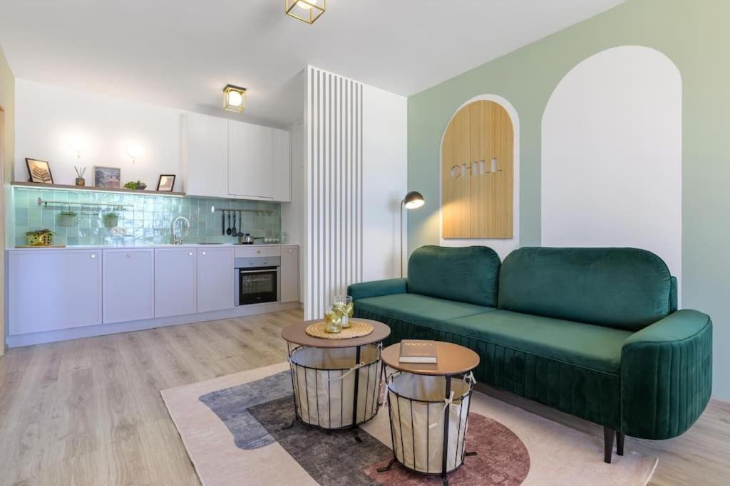 een woonkamer met een groene bank en een keuken bij Mare Vista Suite in Varna
