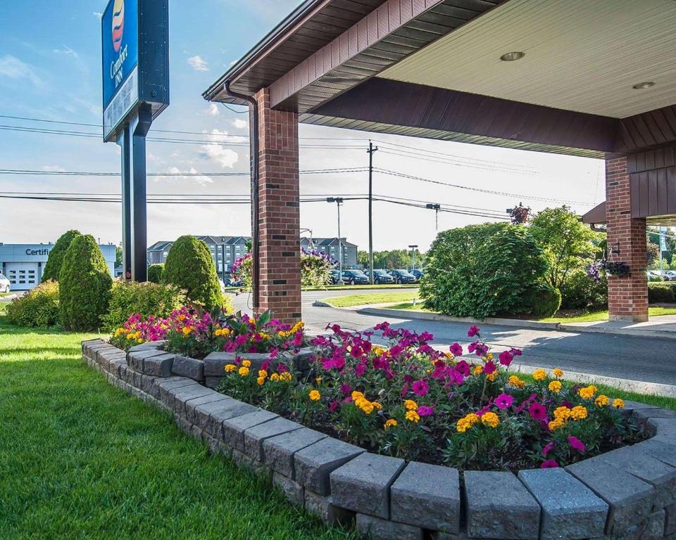 um canteiro de flores em frente a um posto de gasolina em Comfort Inn Fredericton em Fredericton